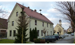 Ehemaliges Schulhaus Bühl, im Hintergrund die Pfarrkirche St. Wendelinus